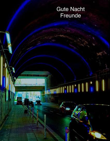A view of a street tunnel at night, featuring illuminated blue and yellow lights on the walls. Cars are visible on the road, and the tunnel opens up to bright light at the far end. The text "Gute Nacht Freunde" is displayed prominently
Ein Blick auf einen Straßentunnel bei Nacht, dessen Wände mit blauen und gelben Lichtern beleuchtet sind. Auf der Fahrbahn sind Autos zu sehen, und am anderen Ende des Tunnels öffnet sich der Blick auf helles Licht. Der Text „Gute Nacht Freunde“ ist deutlich zu sehen.