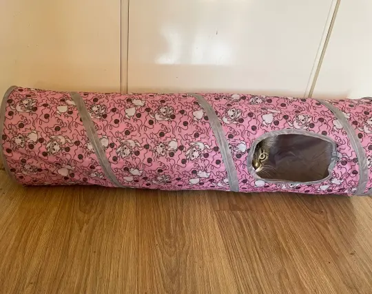 Photo of a cat tunnel next to a kitchen counter. There may or may not be Nova peeking out of it, who can tell