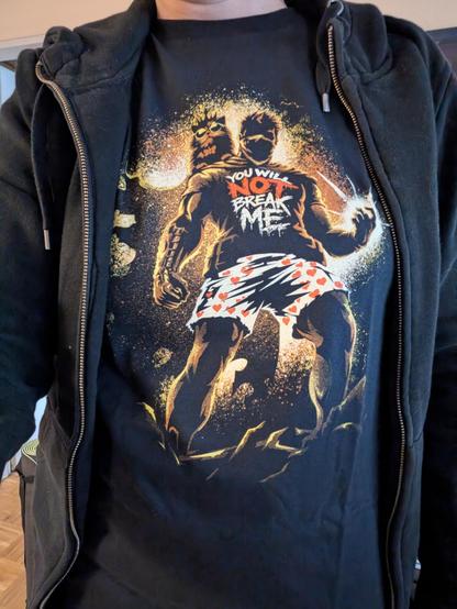 Picture of my shirt. It's a Dungeon Crawler Carl motive, Carl wearing a shirt saying "you will not break me" and of course his boxers, standing in a strong pose. Cat Princess Donut is sitting on his shoulder wearing her sun glasses and crown.