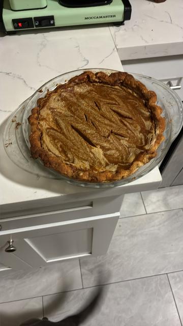 sesame pumpkin pie on a counter with a visible pig tail wagging