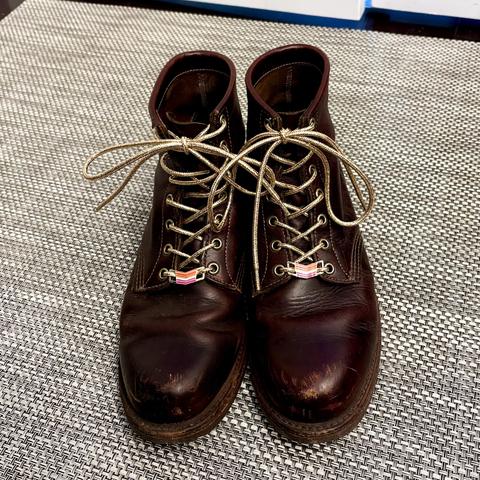 A pair of well-loved leather work boots laced with lesbian bling