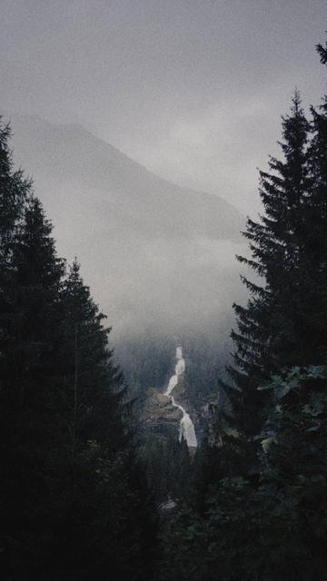 Mountain scenery. Clouds, trees, a waterfall.