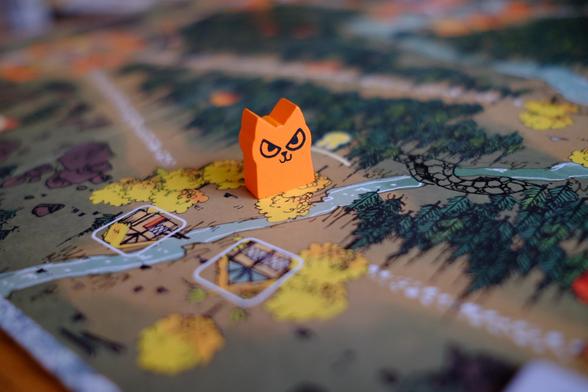 One orange wooden cat figurine with a sinister smile on its face.