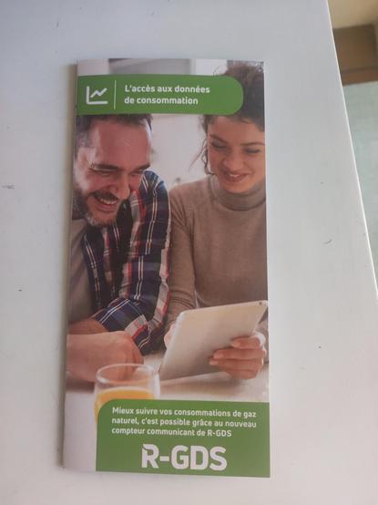 la brochure de R-GDS sur le suivi des consommations de gaz est illustrée par un couple hétéro qui semble trouver beaucoup de joie et de fun dans l'opération en regardant une tablette à côté d'un verre de jus d'orange.