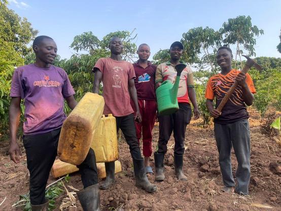 A team of young farmers from Fill the Empty Stomachs Farming Initiative carrying jerrycans and containers to carry the water for irrigating the crops.