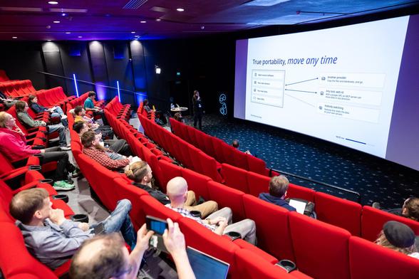 Rolle speaking at Mindtrek about self-hosting, slide is seen on the background: "True portability, move any time" with diagrams