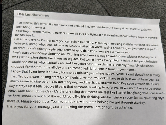 Dear beautiful women, 

I've started this letter like ten times and deleted it every time because every time I start to cry.  So I'm just going to write it.

Your flag matters to me.  It matters so much because it's flying at a lesbian household where anyone walking by can see it.

I'm a trans girl so I'm not sure you can relate but I'll try.  Most days I'm doing math in my head like which hallway is safe, who I can sit near at lunch whether it's worth saying something or just letting it go.  I'm so tired.  I don't think people who don't have to do it know how tired it makes you.

I walk past your house almost daily.  The first time I saw the flag I slowed down without meaning to.  It was just hanging there like it's no big deal but to me it was everything.  I felt like the people inside the house would see me as I actually am and I wouldn't have to explain or prove anything.  My shoulders dropped for the first time all day and I almost cried right there outside your house.

I know living here isn't easy for gay people like you where not everyone is kind about is so putting that flag up risks stares, comments or worse.  You didn't have to do it.  It would have been so much easier to stay quiet. You did it anyway, and that is the bravest thing I've seen anyone do.  Every day it stays up tells people like me that someone is willing to be brave so we don't have to feel alone.

Now I look for it.  Some days it's the one thing that makes me feel I'm not imagining that I deserve to be here.  When so much of the world feels like it's deciding whether there's room for me your flag says there is.  Please keep it up.  You might not know it but it's helping me get through the day.

Thank you for your courage, and for leaving the porch light on for the rest of us.