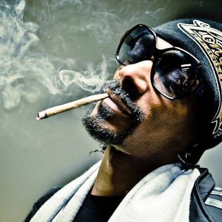 smoke curls from both the joint hanging from the lips of, and from the nostrils of Snoop Dogg