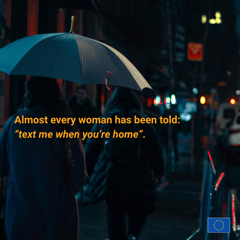 A photo of a woman holding an umbrella walks down a dark city street at night. Overlaid orange text reads: "Almost every woman has been told: 'text me when you're home'." In the bottom right corner is the European Union flag logo