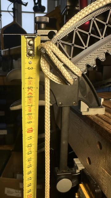 testing setup with a tape measure and 3d printed gear being pulled downwards by a 2kg weight.  only about 1cm of deflection compared to 8cm in the previous photo.