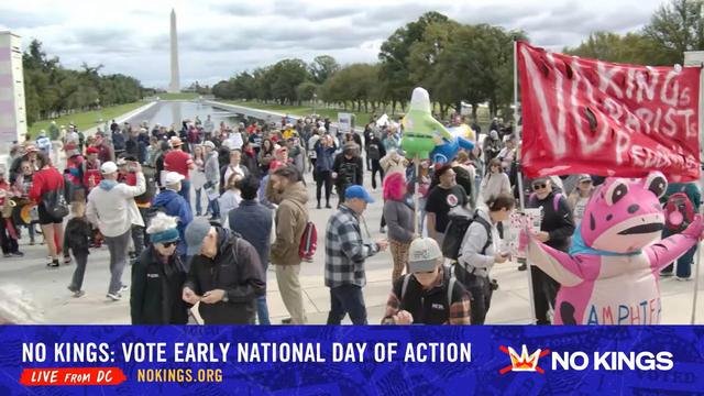 Still from live video
Lincoln pool and Wash monument are in the background
People are milling around with signs and cameras
A pink frog hold up a No Kings sign.