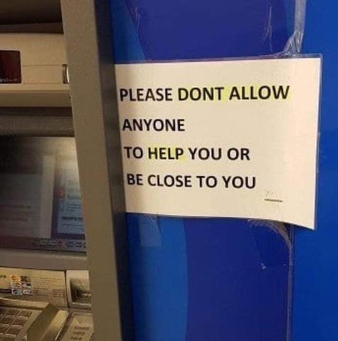 This photograph shows a strangely worded security notice taped to the side of an ATM.

The setting: On the left side of the image is a gray automated teller machine, partially cut off by the edge of the photograph. Its screen, keypad, and card slot are visible.

To the right is a bright blue wall or partition, with a rectangular sheet of white paper attached using clear tape.

The sign: Printed in large, bold, black capital letters, the notice reads:

> please dont allow
>
> anyone
>
> to help you or
>
> be close to you

There is no apostrophe in "DONT," and the awkward line breaks make the message appear particularly abrupt and commanding.

The joke: The sign is probably intended as a legitimate ATM security warning, advising customers not to accept assistance from strangers or allow anyone to stand close enough to see their PIN.

However, when read without the context of ATM security, it sounds like an incredibly bleak piece of life advice.

Instead of simply warning people to protect their banking information, the sign seems to be instructing them to reject all human kindness, refuse assistance, and maintain emotional and physical distance from everyone.

The phrase "please dont allow anyone to help you or be close to you" could almost be the personal philosophy of an extremely lonely, distrustful individual.

The humor comes from the contrast between the sign's perfectly reasonable purpose and its accidentally depressing message.

It's essentially an ATM telling you:

"Trust nobody. Accept no kindness. Never let anyone get close to you."

A routine banking security notice has inadvertently become a manifesto for emotional isolation.