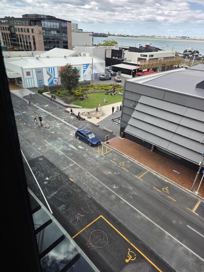 Elevated pic of a street that is covered in chalk doodles