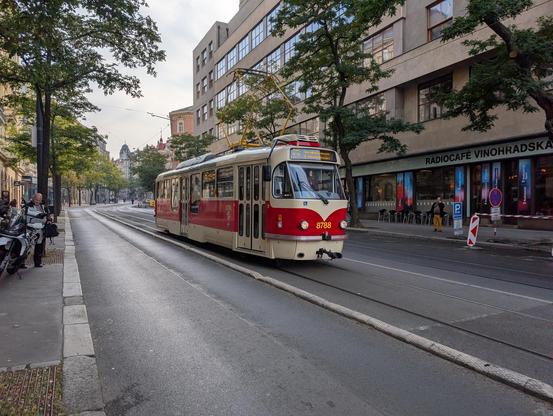 Vintage tram car in a street free of parked cars.