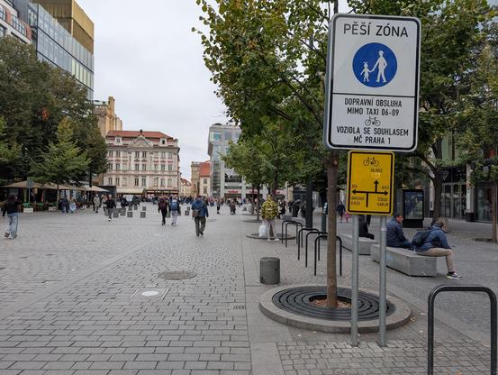 Sign announcing the entrance of the pedestrian zone, with bicycles and taxis allowed, and some bicycle directions.