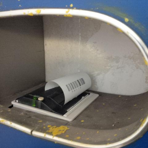 Close-up view of a small receipt printer mounted in a metal cubby.