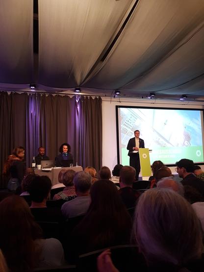 Saal im Forum in Kreuzberg

Am Pult steht Werner Graf und redet