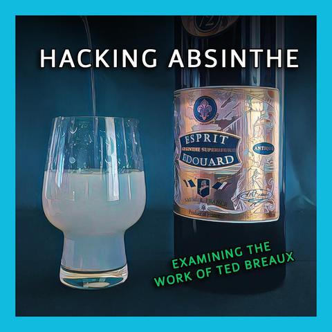 Photograph of a glass of absinthe being louched by a stream of water while a beautiful bottle with a gold and blue foil label sits beside it.