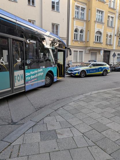 MVG Bus wird beim Abbiegen von abgestelltem Polizeifahrzeug blockiert.