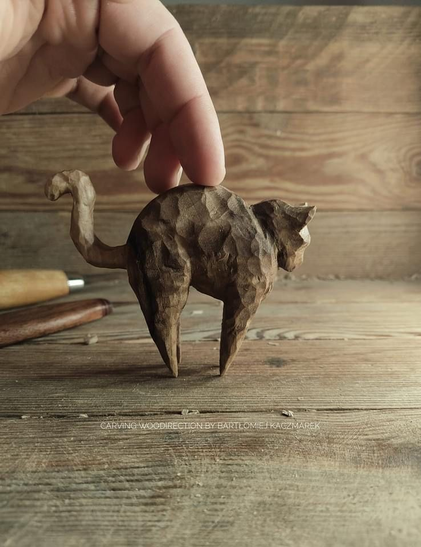 This is a handmade wooden cat figurine (Stretching Cat), carved from walnut wood by woodcarver Bartłomiej Kaczmarek (known as Woodirection).
