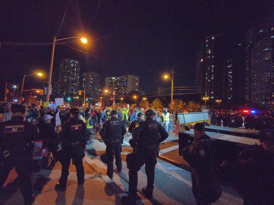 A large number of cops guarding rear of truck where trailer and machine is
