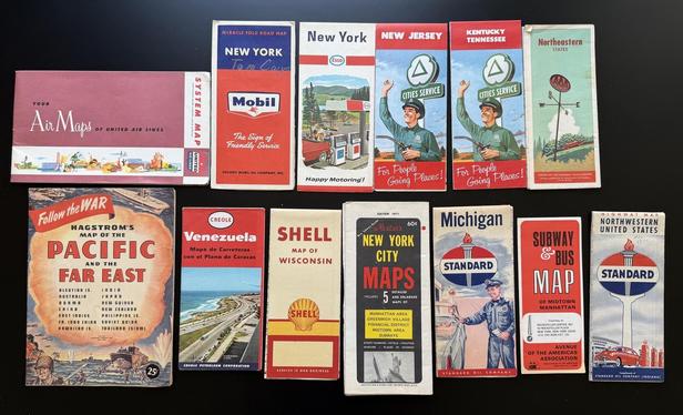 A bunch of colorful old printed maps - New York, Venezuela, Michigan, etc. This image shows the front of the maps.