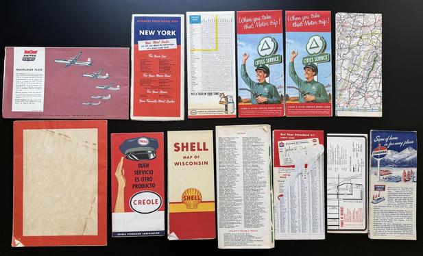 A bunch of colorful old printed maps - New York, Venezuela, Michigan, etc. This image shows the back of the maps.