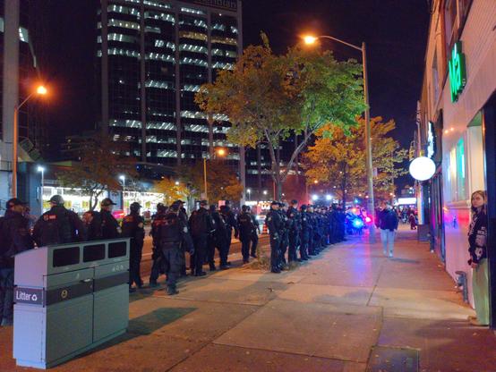 Two dense lines of riot cops lining the sidewalk on Bloor near Islington