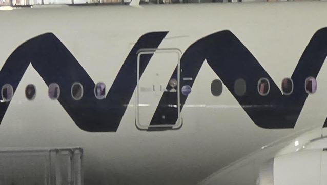 The two N's from the Finnair logo on the side of a plane. Shot is taken through the window of another A350 and is kind of grimy and just out of focus. The photographer apologises for the poor shot.