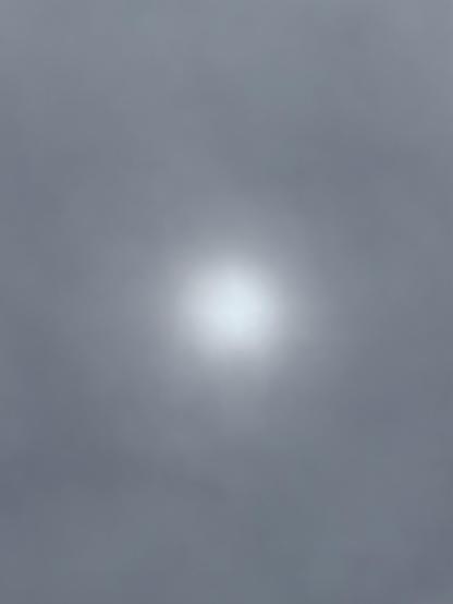 Bluish-gray clouds, with a fuzzy, indistinct roundish light in the center.