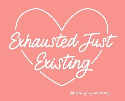 Peachy pink background with a white heart and white text inside that says "exhausted just existing."