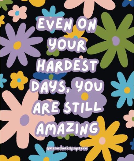 Black background with purple, yellow, green, blue and pink flowers. White text surrounded by purple in the centre of the pic reads "Even on your hardest days, you are still amazing."