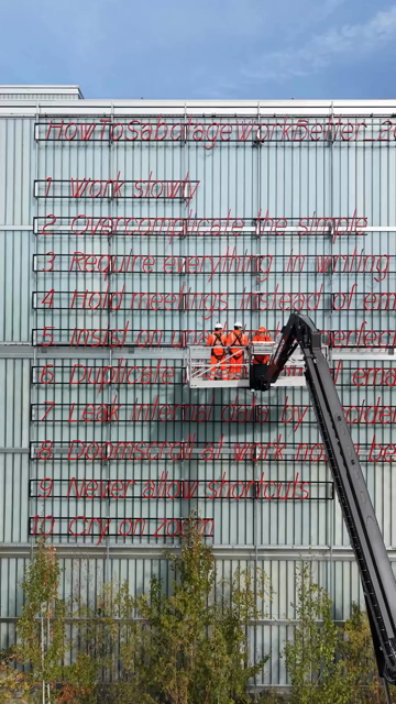 Daytime drone shot of the neon LED installation «HowToSabotageWorkBetter_2027.pdf» being installed on the façade of the Energiezentrale Josefstrasse, Zurich.