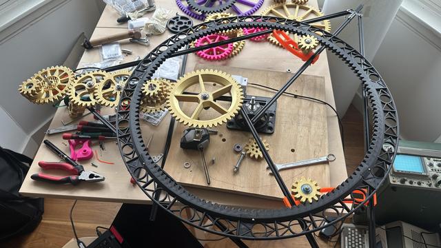 Large clockwork mechanism with a skeletal ring gear supported by gold gears