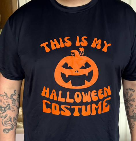 Picture of me (a year or two ago when I was a bit leaner)cropped to just show torso and send and wearing a blue shirt with an orange pumpkin on and the words “this is my Halloween costume”