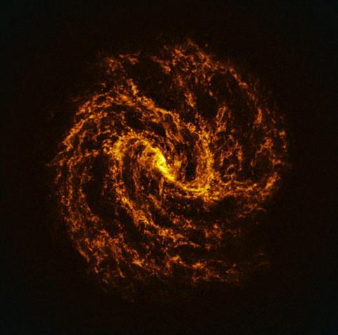 Glowing orange spiral of gas and dust forming a turbulent, galaxy-like swirl with a bright central core and filamentary spiral arms against a dark background.