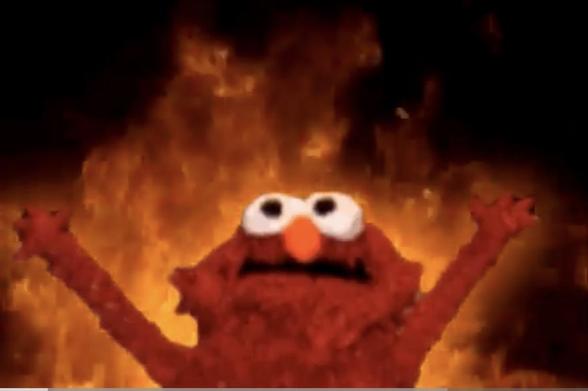 Hellmo: a scrungly version of Elmo, his arms raised, eyes upward, in front of flames