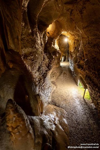 Path leading through a narrow cave. Lights are mounted on floor level