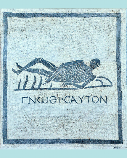 The mosaic has a white background with a reclining skeleton in black with Greek inscription below. There is an alternating black and white border.