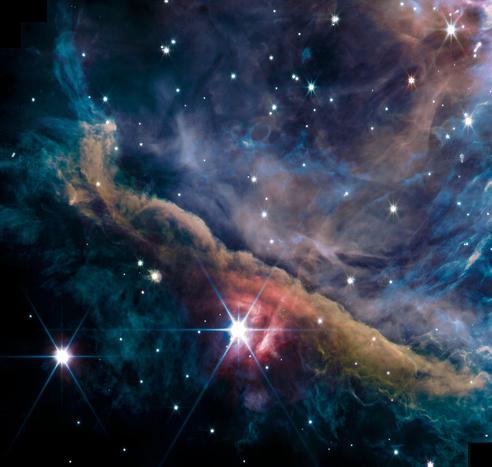 A colorful star-forming nebula with bright, diffraction-spiked stars scattered across wispy teal, blue and rose clouds of glowing interstellar dust.